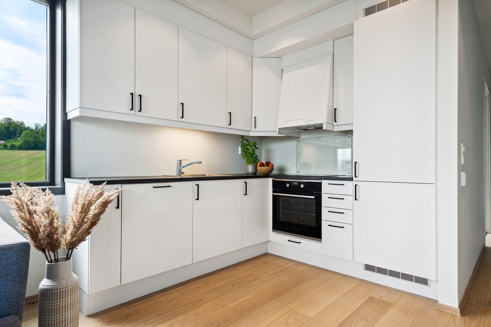 Praktisk kjøkken med integrert oppvaskmaskin, stekeovn og kjøl-/fryseskap. Galleribilde