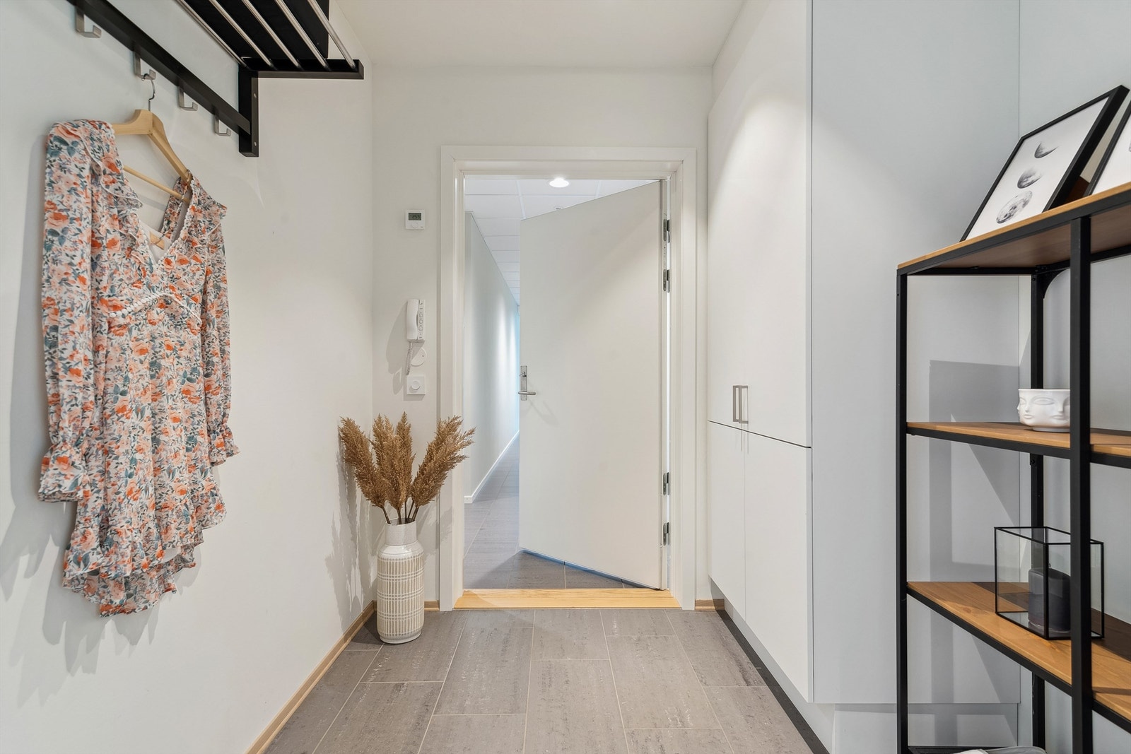 Fin og lys entré med plass for sko og yttertøy i garderobeskap. Galleribilde