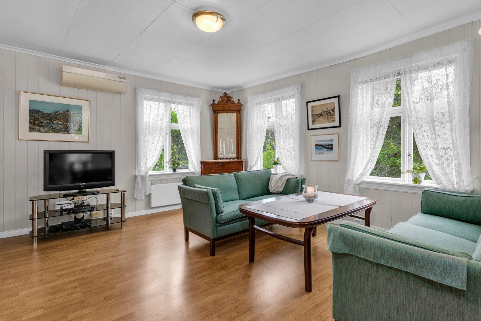 De lysmalte veggene og laminatgulvet gir stuen et lyst og hyggelig uttrykk. Galleribilde