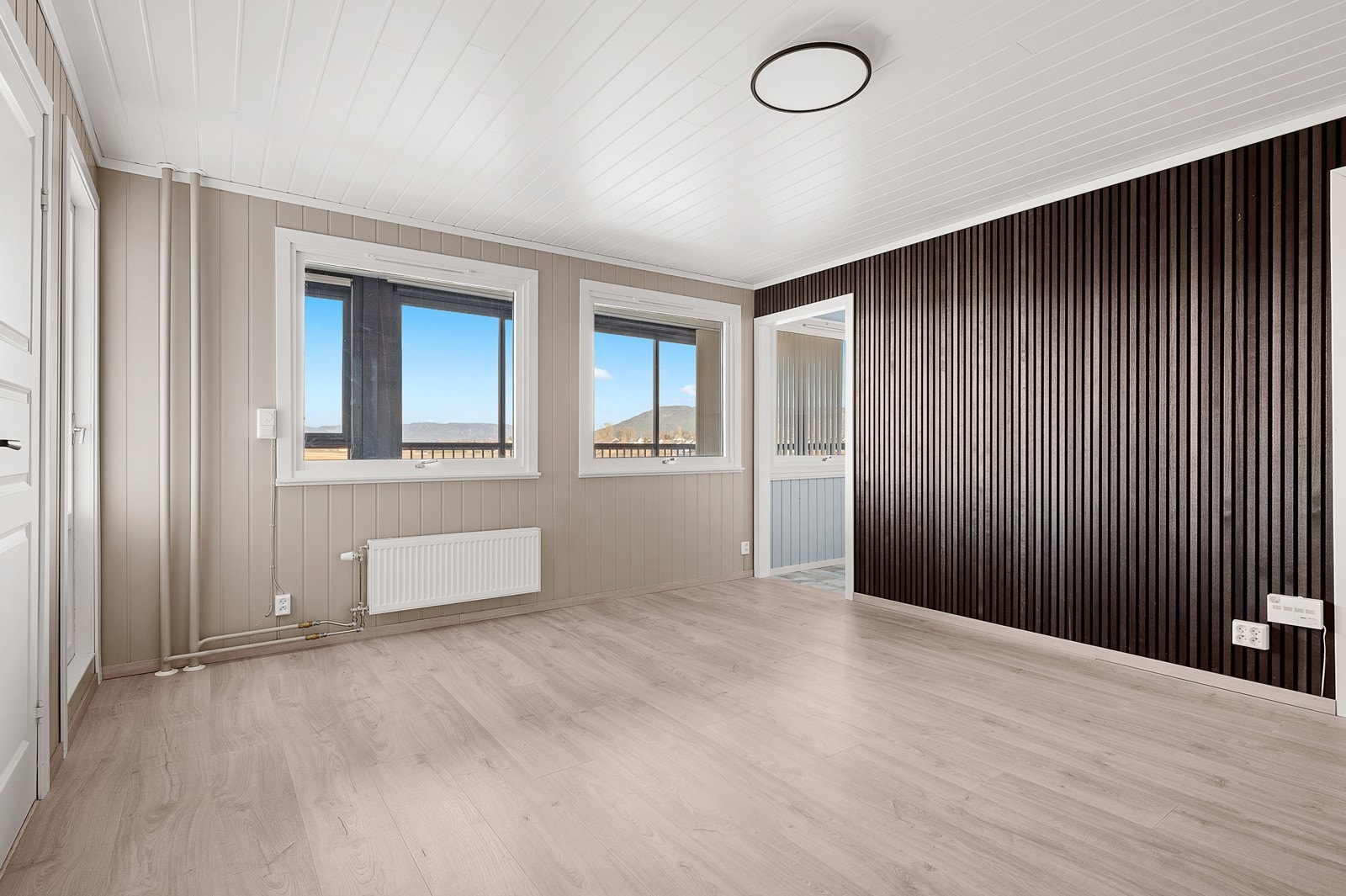 Det er lagt ny laminat på gulvet og panel på veggene. Det er også bygget opp en spilevegg mot kjøkkenet Galleribilde