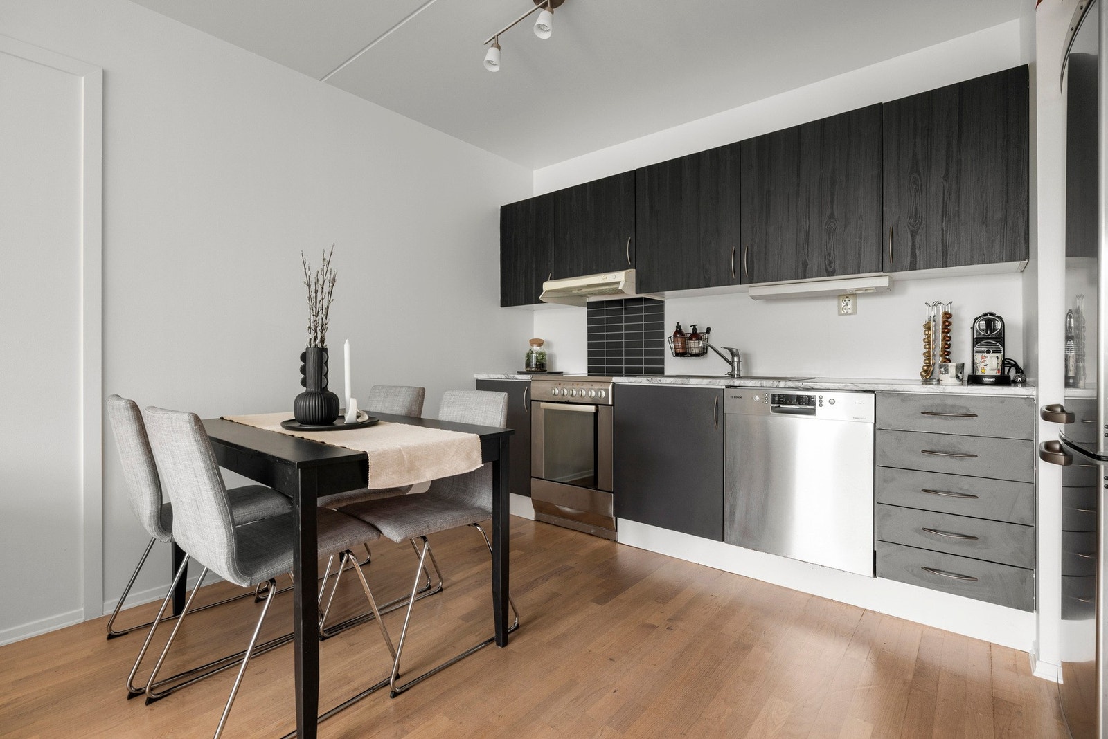 Kjøkkenet er og innredet med oppvaskmaskin, oppvaskkum og komfyr med keramisk platetopp Galleribilde