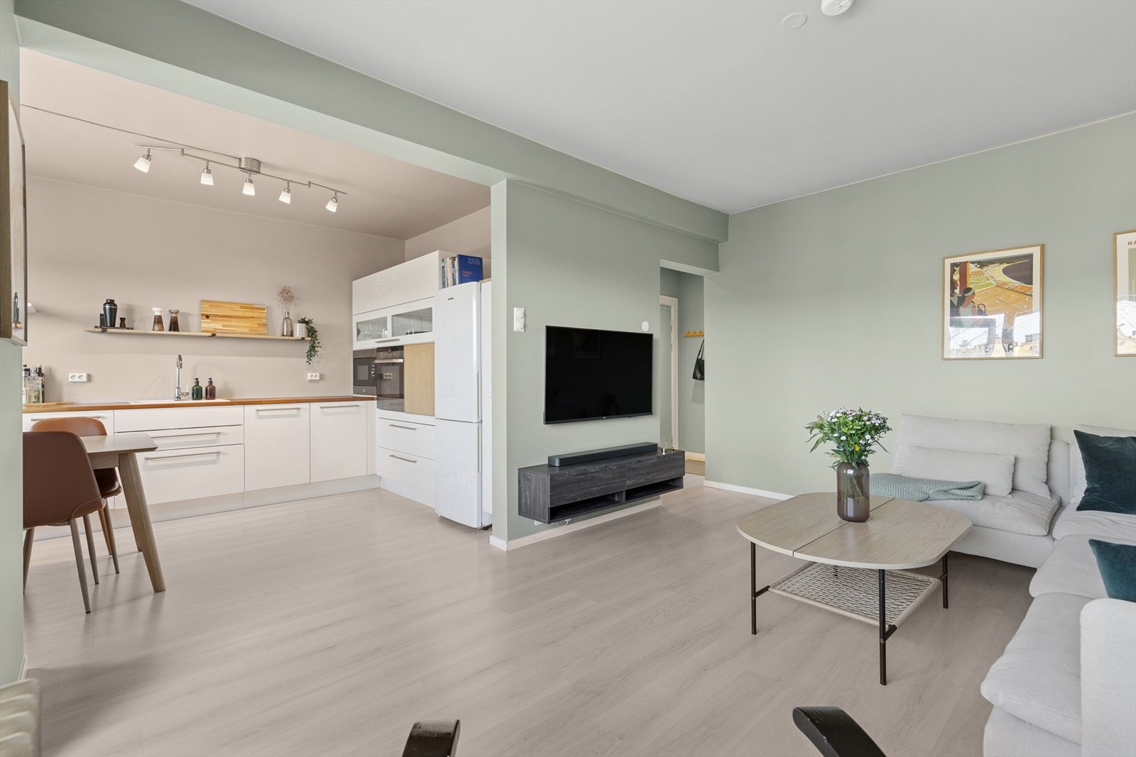 Stue/kjøkken i åpen løsning. Her er det lys og luftig takket være boligens lyse overflater Galleribilde