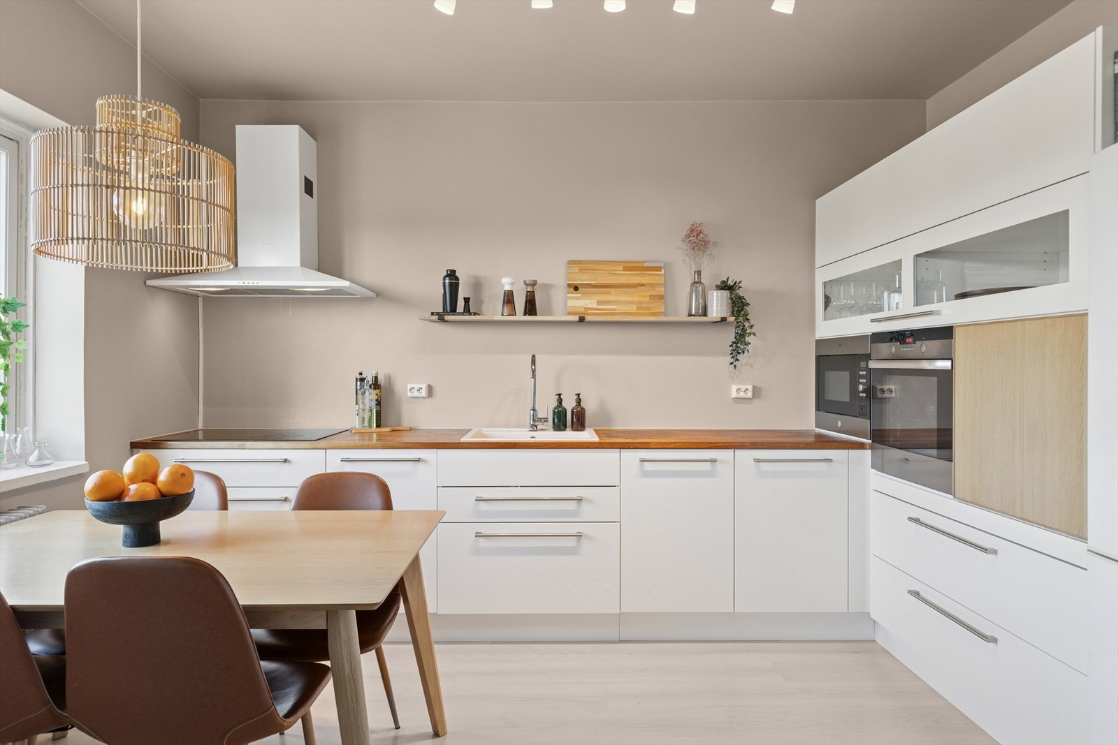 Kjøkkeninnredning med heltre benkeplate med nedfelt kjøkkenvask og innebygget oppvaskmaskin Galleribilde