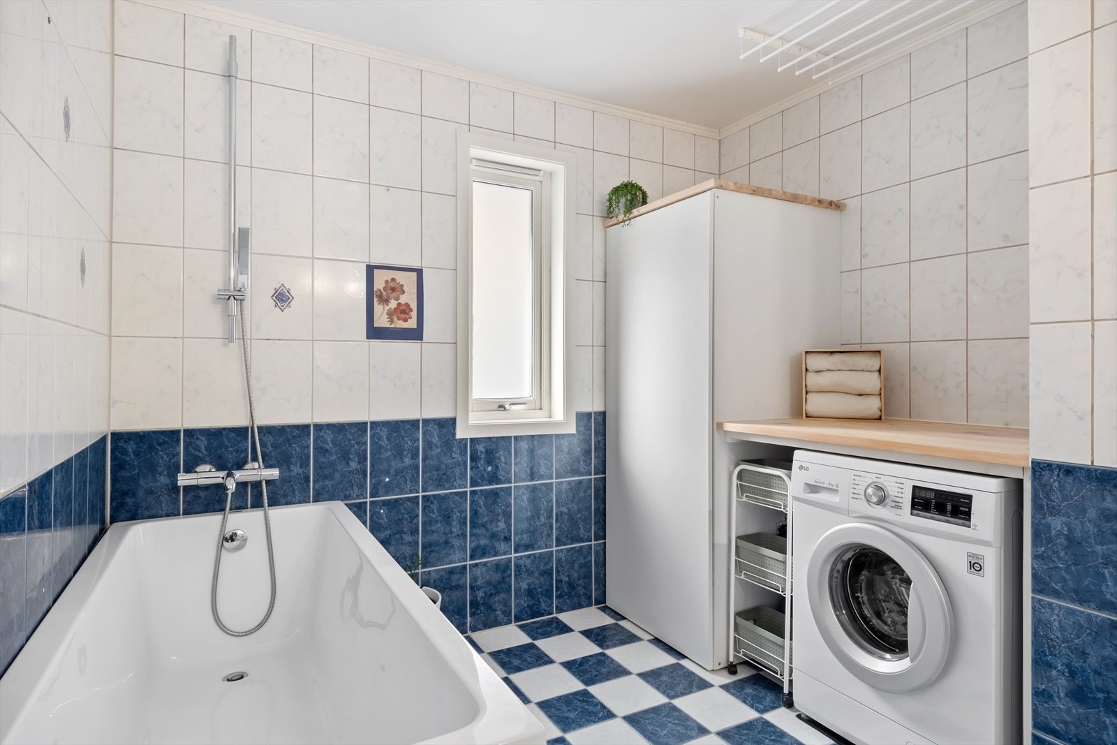 Badet er av god storleik og er utstyrt med toalett, badekar, servant med underskåp og opplegg for vaskemaskin med arbeidsbenk. Galleribilde