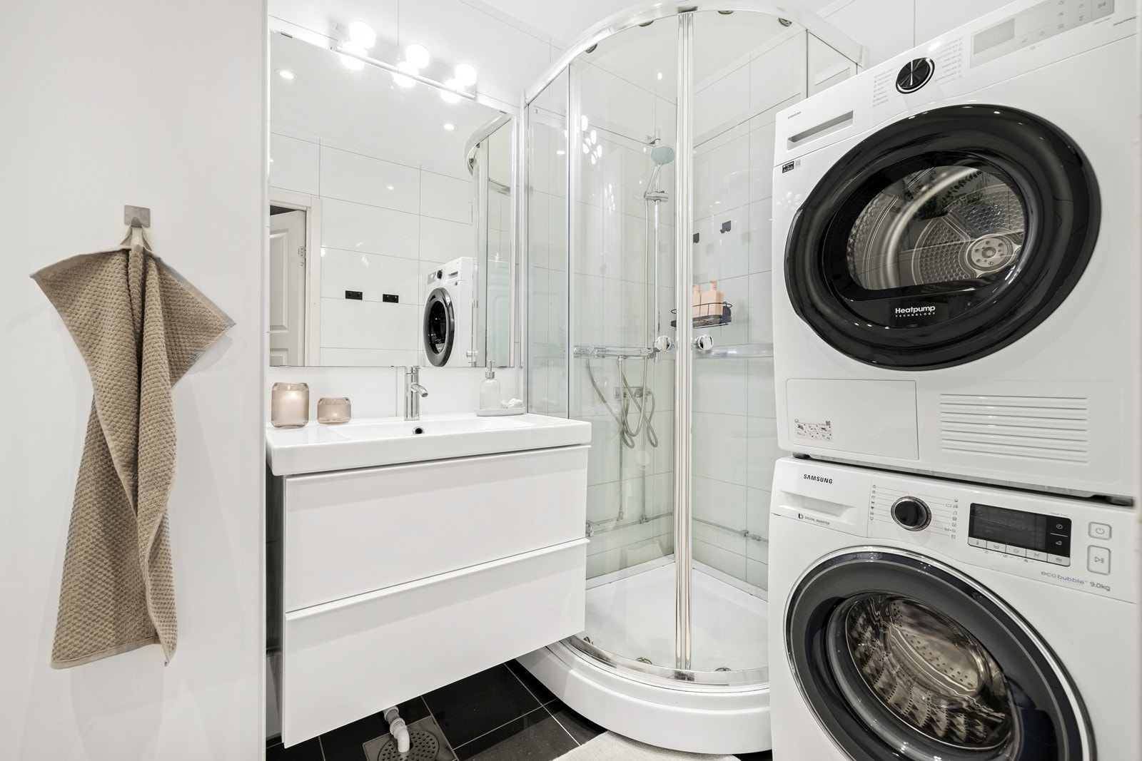 Tidløst pent, flislagt baderom. Det er opplegg for vaskemaskin og tørketrommel. Galleribilde