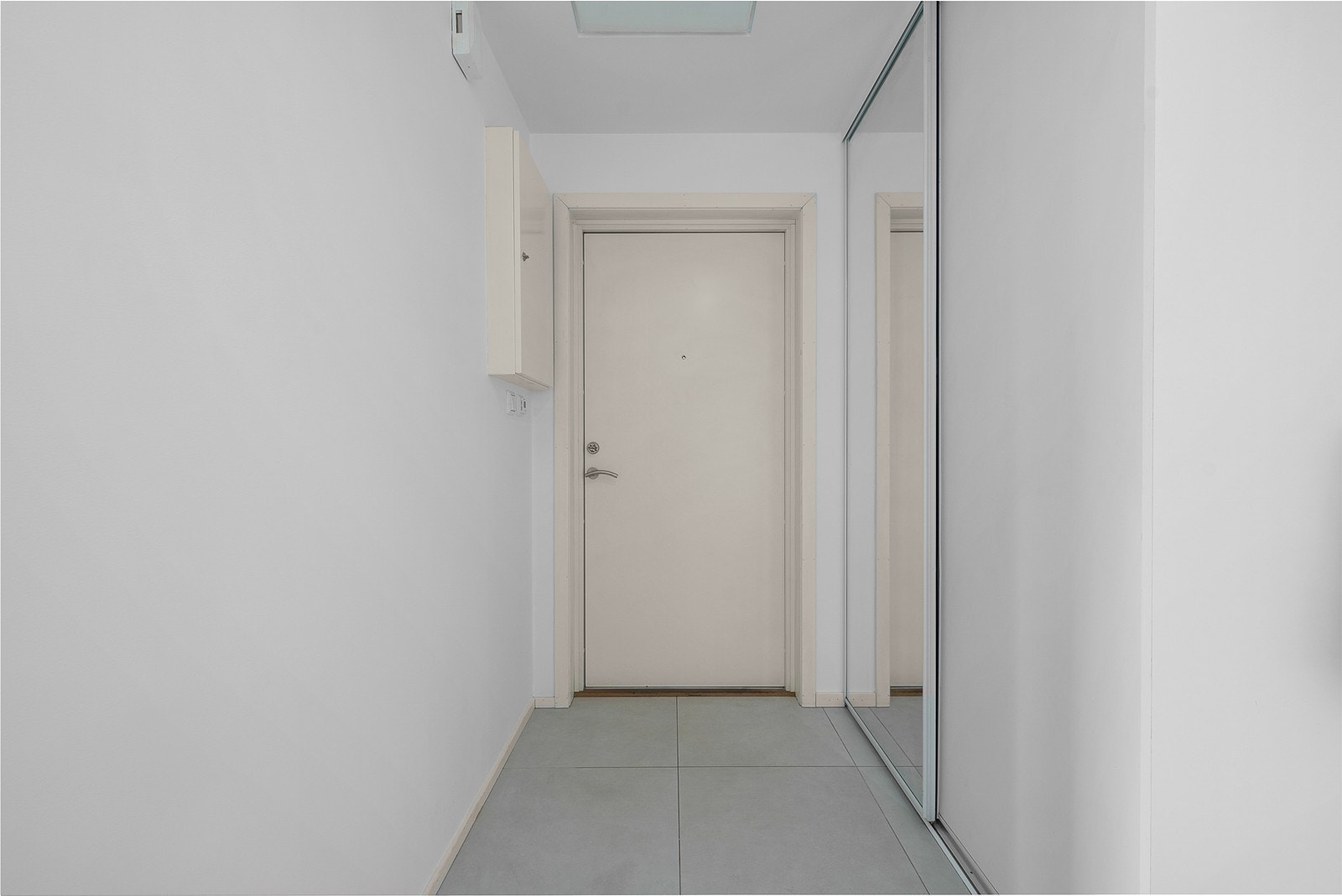 Entré er flislagt med varmekabler. Her er det også en praktisk skyvedørsgarderobe. Galleribilde