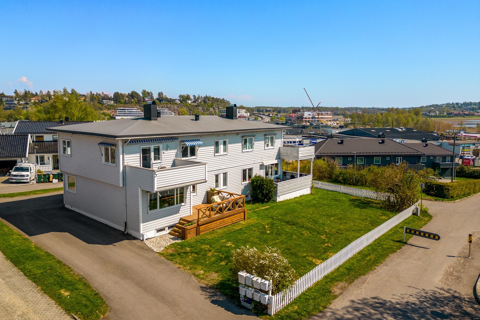 Hagen er pent opparbeidet med plen, noe beplantning og hvitt stakittgjerde. Galleribilde