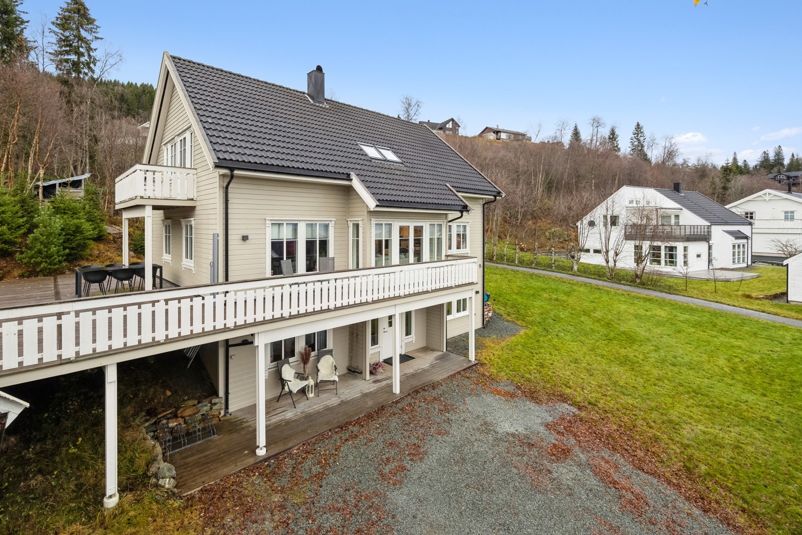 Tomt opparbeidet med grus, diverse beplantninger og plenareal. Galleribilde