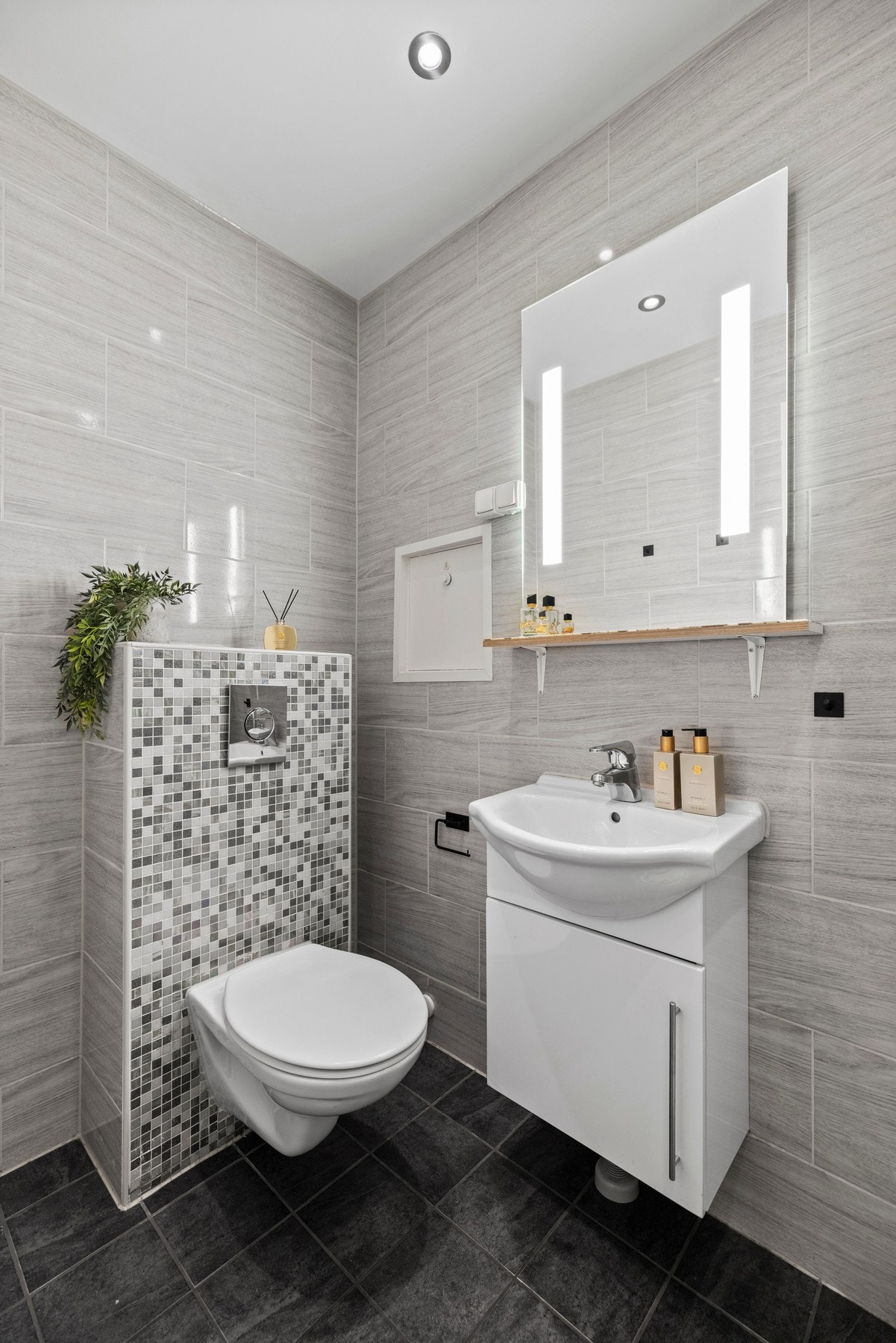 Lyst og tidløst baderom fra 2014 med innredning bestående av
nedfelt servant, toalett og dusjkabinett. Speil med lys og tilhørende hylle for ekstra oppbevaring. Galleribilde