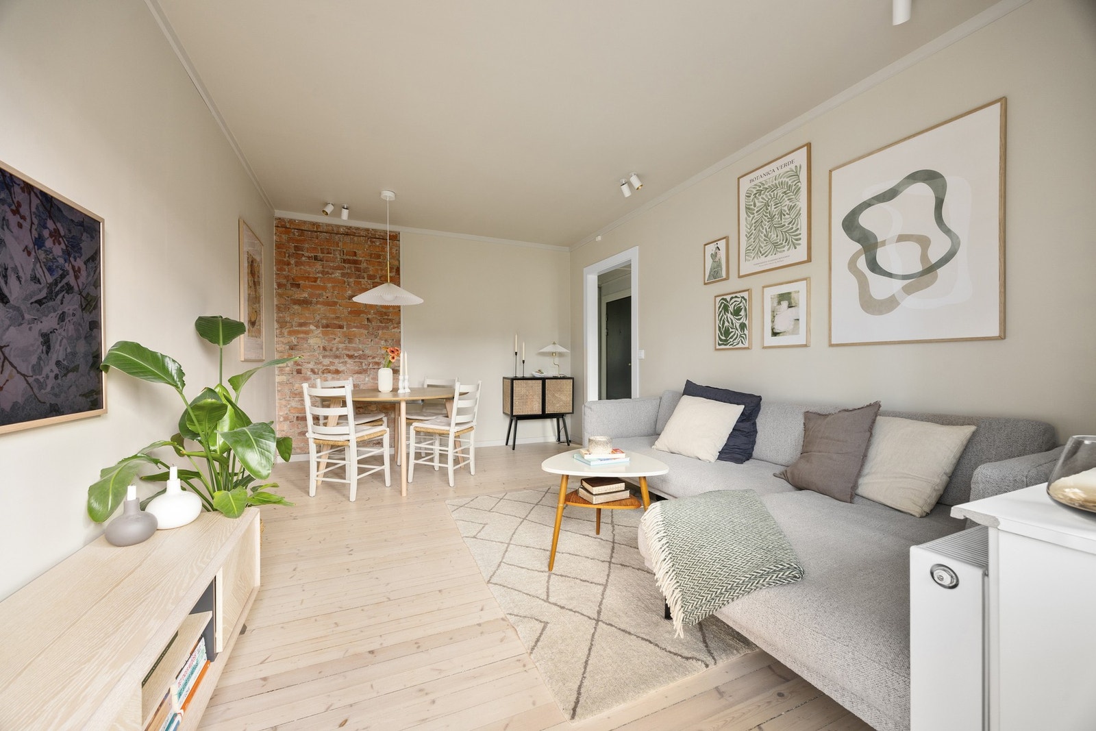 Klassiske detaljer som teglsteinsvegg i stuen gir leiligheten særpreg. Galleribilde