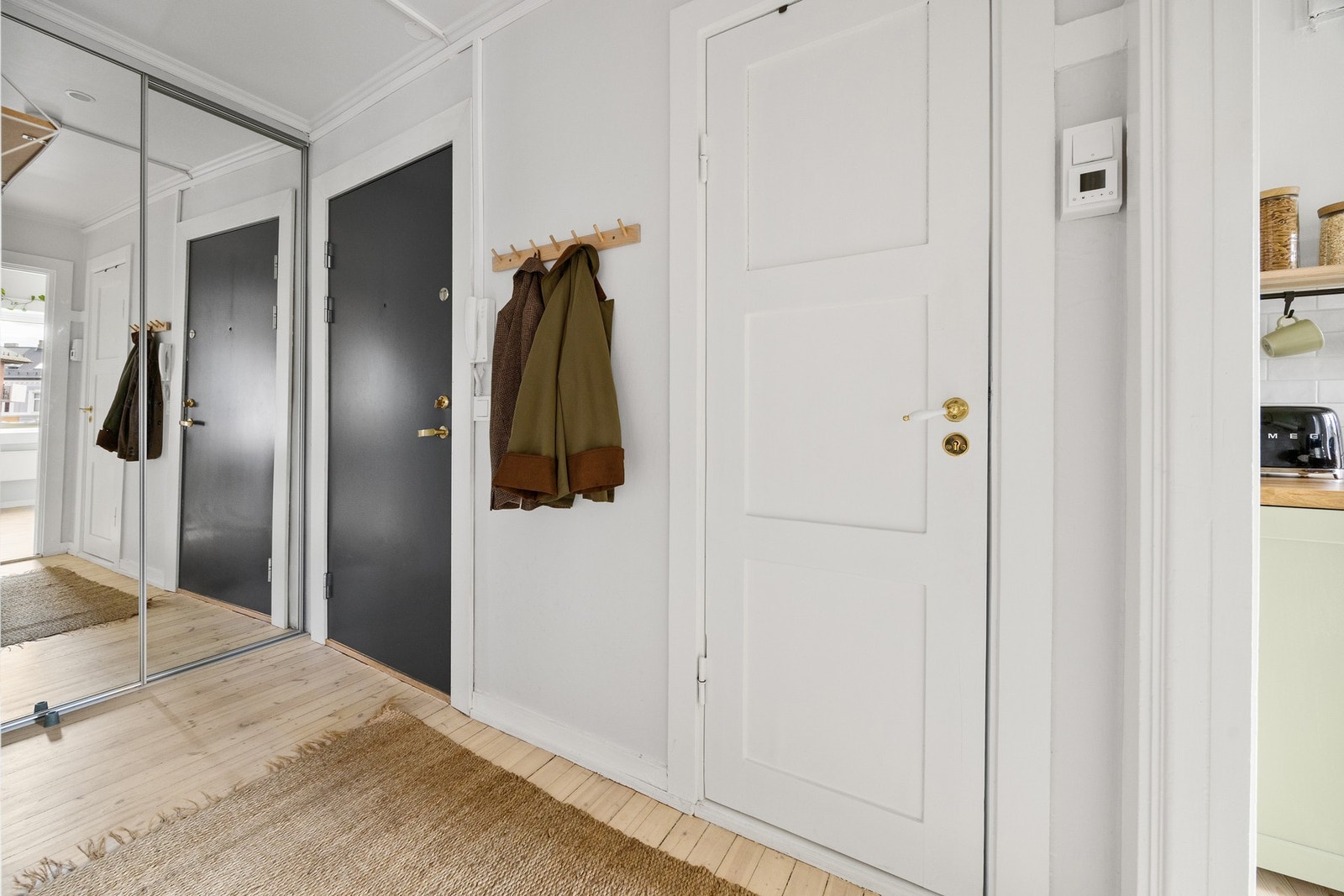 Lys entré med skyvedørsgarderobe. Dørcalling er montert ved døren. Galleribilde