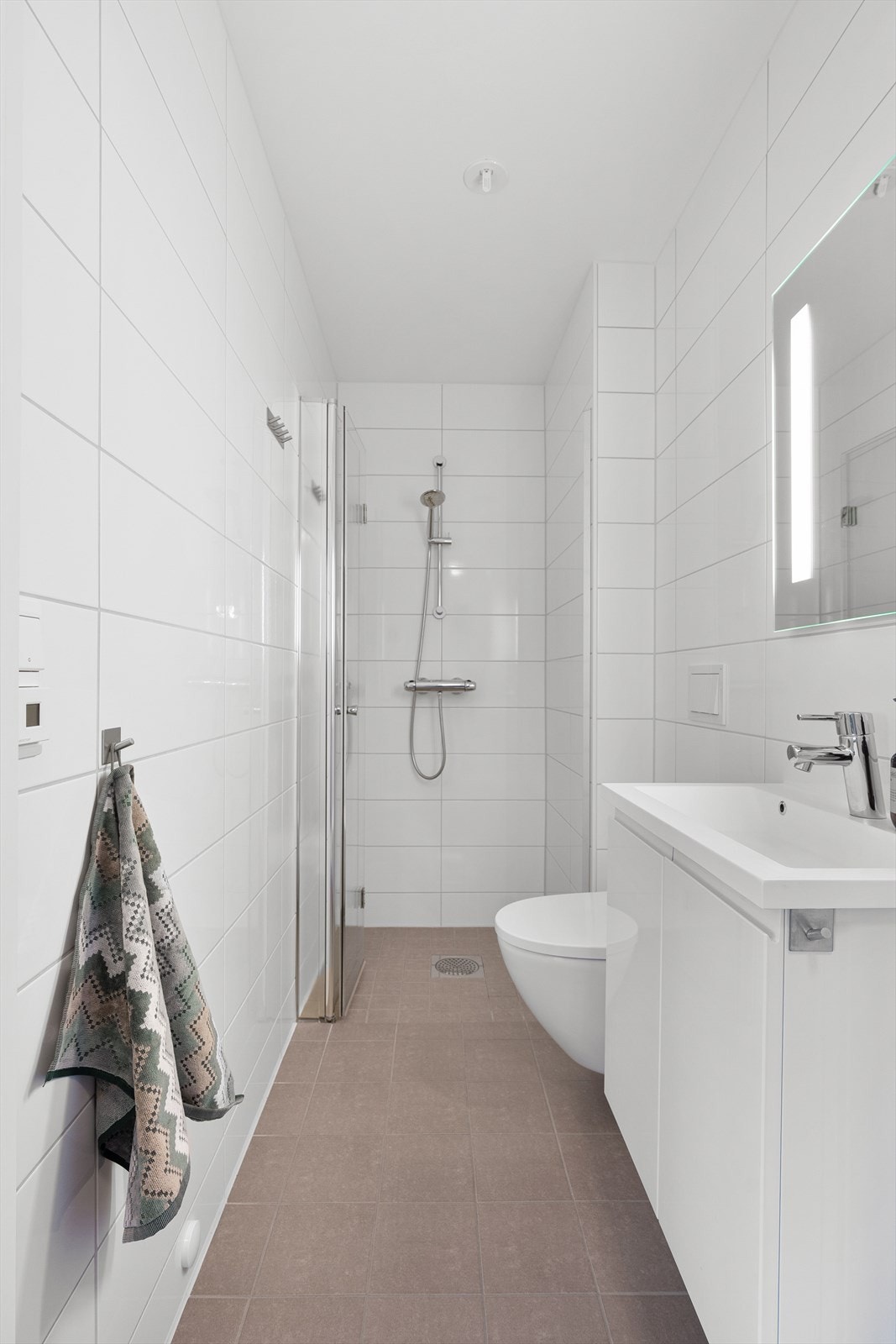 Boligen byr på et delikat og tidsriktig bad med flislagte overflater på gulv og vegger. Galleribilde