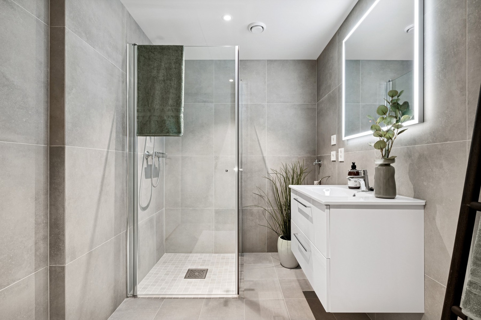 Baderommet er utstyrt med baderomsinnredning, servant. dusj, vegghengt klosett og opplegg for vaskemaskin. Galleribilde