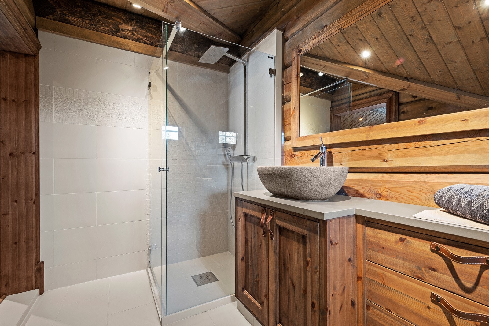 Badet inneholder plassbygget innredning med toppmontert servant, vegghengt toalett og dusjnisje Galleribilde