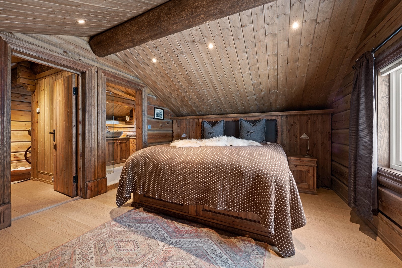 Rommet har full takhøyde, plassbygget dobbeltseng og nattbord i samme stil Galleribilde