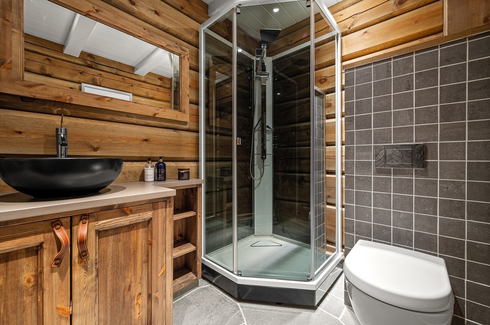 Badet i første etasje har fantastiske tømmervegger og skifer på gulv med vannbåren varme Galleribilde