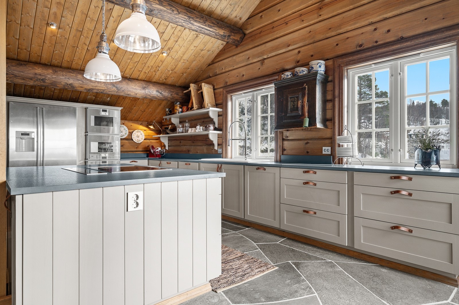 Praktisk og innbydende kjøkkenøy hvor man kan lage mat mens man deltar i samtalene med gjester/familien Galleribilde