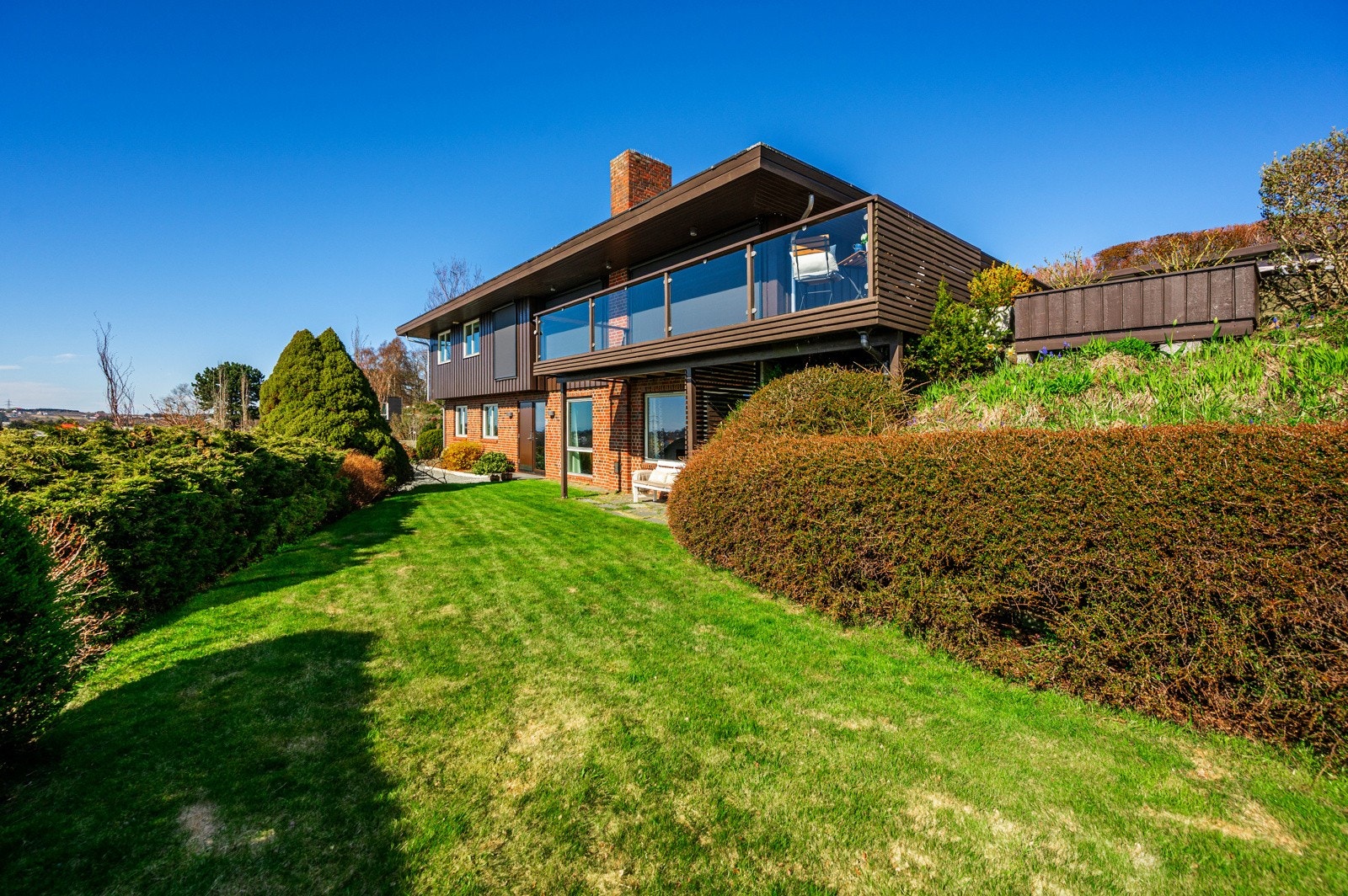 Tomten er pent opparbeidet med velstelt hage, prydbusker og terrasser. Galleribilde