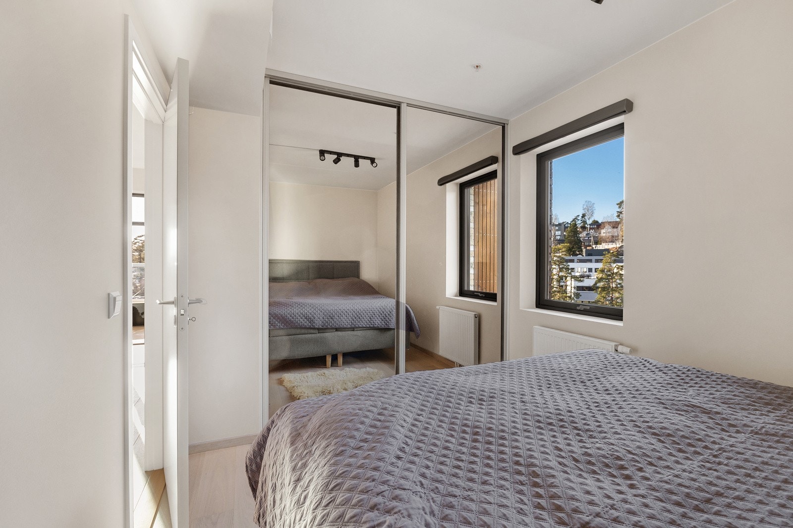 Romslig hovedsoverom med stor skyvedørsgarderobe Galleribilde