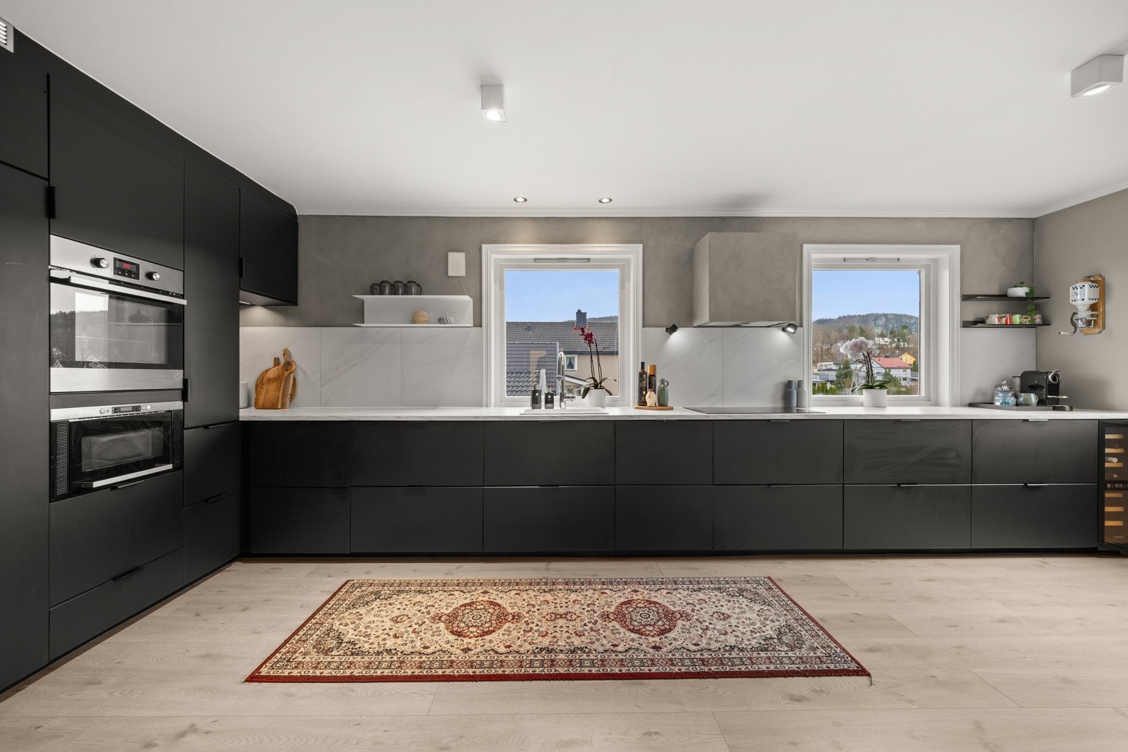 Komplett utstyrt med integrerte hvitevarer som oppvaskmaskin, kjøleskap, stekeovn, induksjonstopp, micro og vinskap. Galleribilde