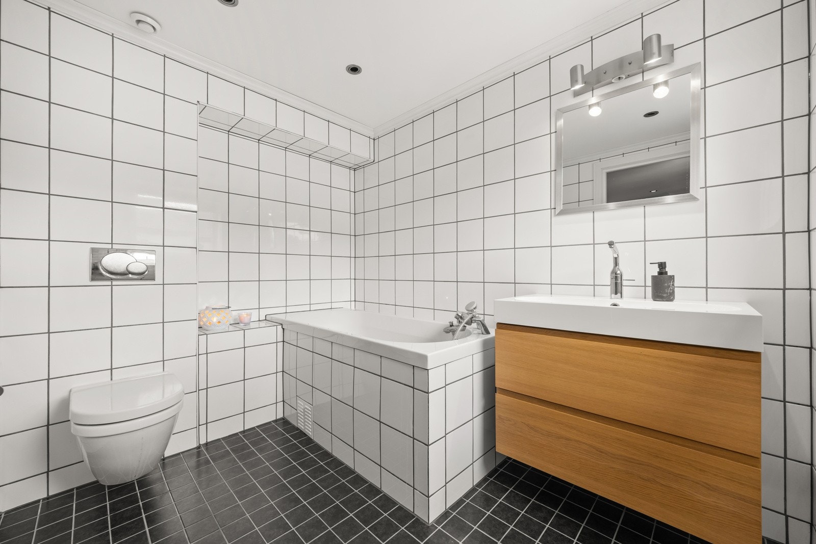 Helfliset bad med varmekabler i gulvet og innmurt badekar. Galleribilde