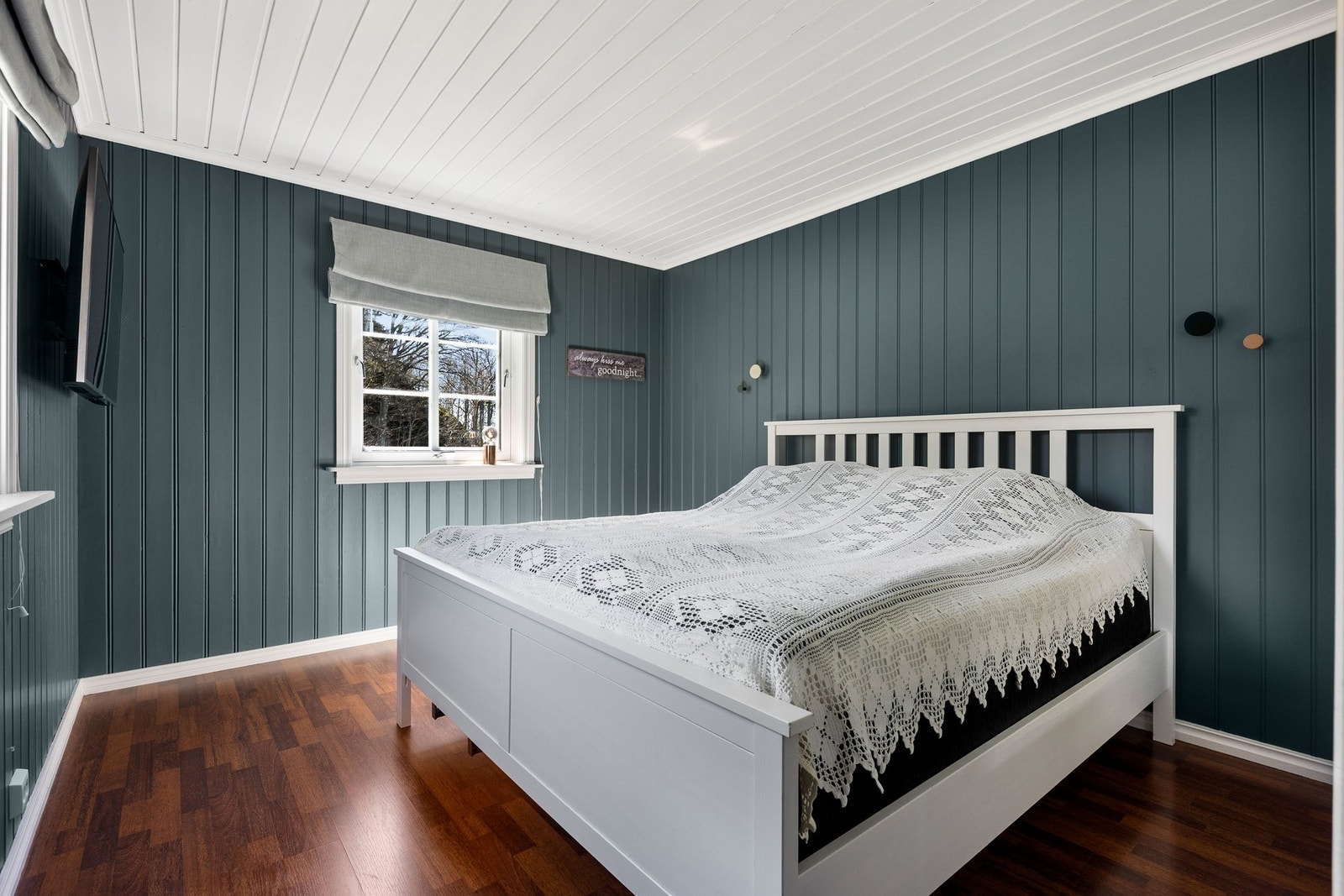 Stort soverom med blåmalt panel på vegger. Her er det plass for ytterligere møblering. Galleribilde