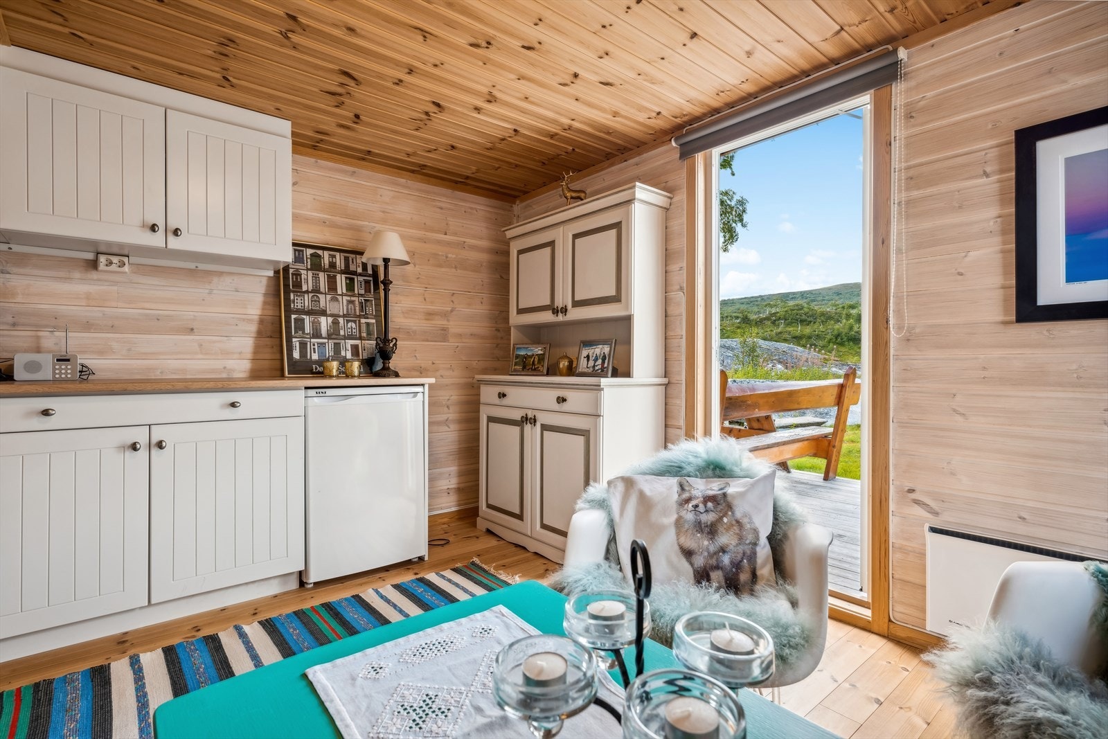 Det er etablert enkel kjøkkeninnredning med kjøleskap, benkeplass og skap Galleribilde