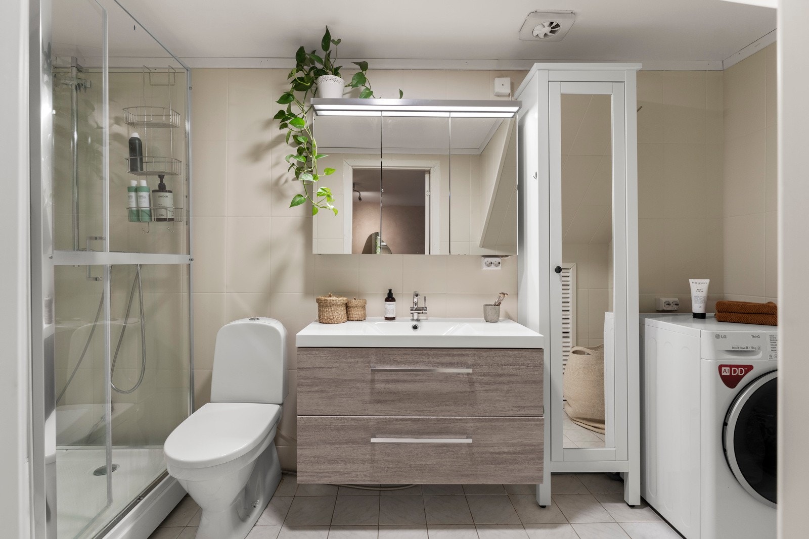 Badet er innredet med dusjkabinett fra 2022, gulvmontert toalett og servant med underskap og speilskap. Det er opplegg for vaskemaskin. Rommet har flislagt gulv, malt flis på vegger og malte plater i himling. Galleribilde