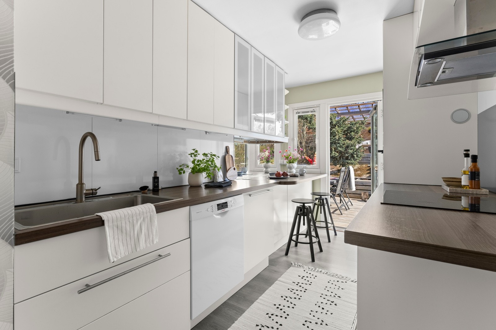 Kjøkkenet har innredning fra IKEA med glatte, hvite og delikate fronter, samt laminat benkeplate. Det er integrerte hvitevarer som kjøl-/fryseskap, induksjonstopp og stekeovn, mens oppvaskmaskinen er frittstående. Galleribilde