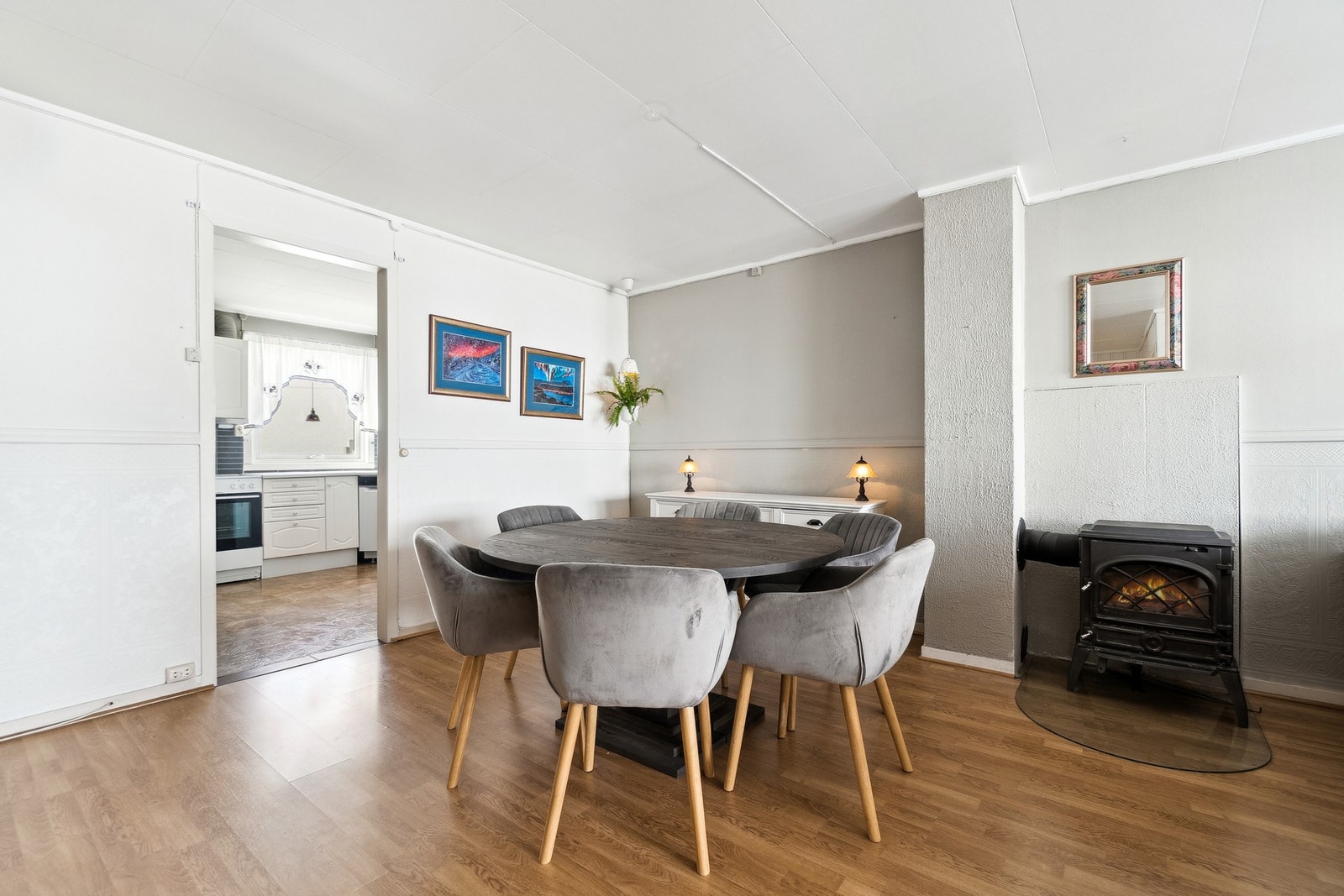 Stuen har en vedovn sentrert i etasjen for praktisk oppvarming og hygge på kaldere årstider. Galleribilde
