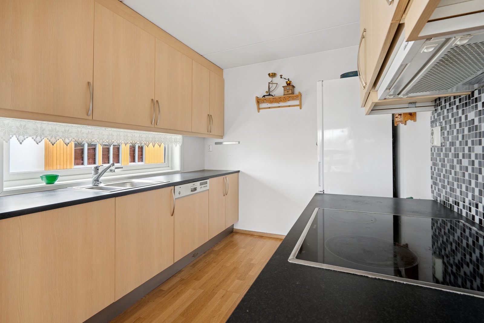 Kjøkkenet har godt med skapplass og benkeareal, samt en livlig mosaikkflis som gir rommet karakter og farge. Galleribilde