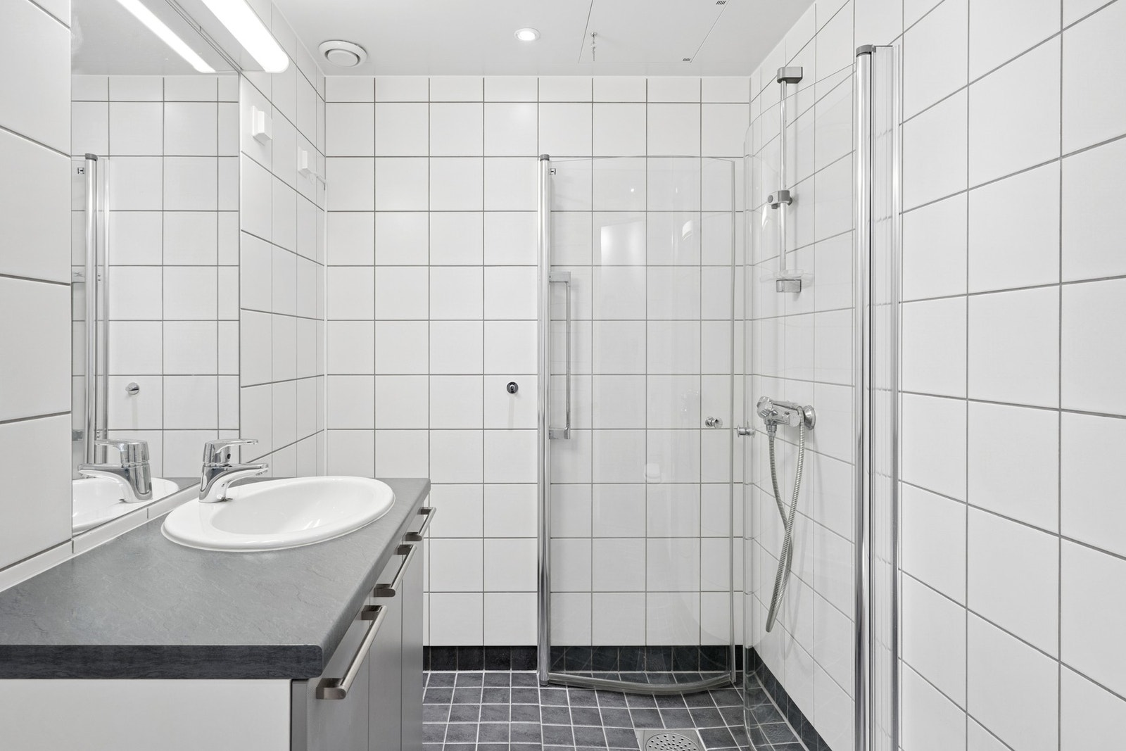 Badet har flislagt gulv med varme, flislagte vegger og vegghengt toalett. Galleribilde