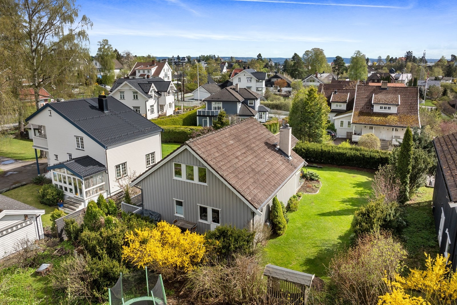 Tomten er pent opparbeidet med en vakker beplantet hage og hekk mot nabo, som bidrar til lune og private soner. Galleribilde