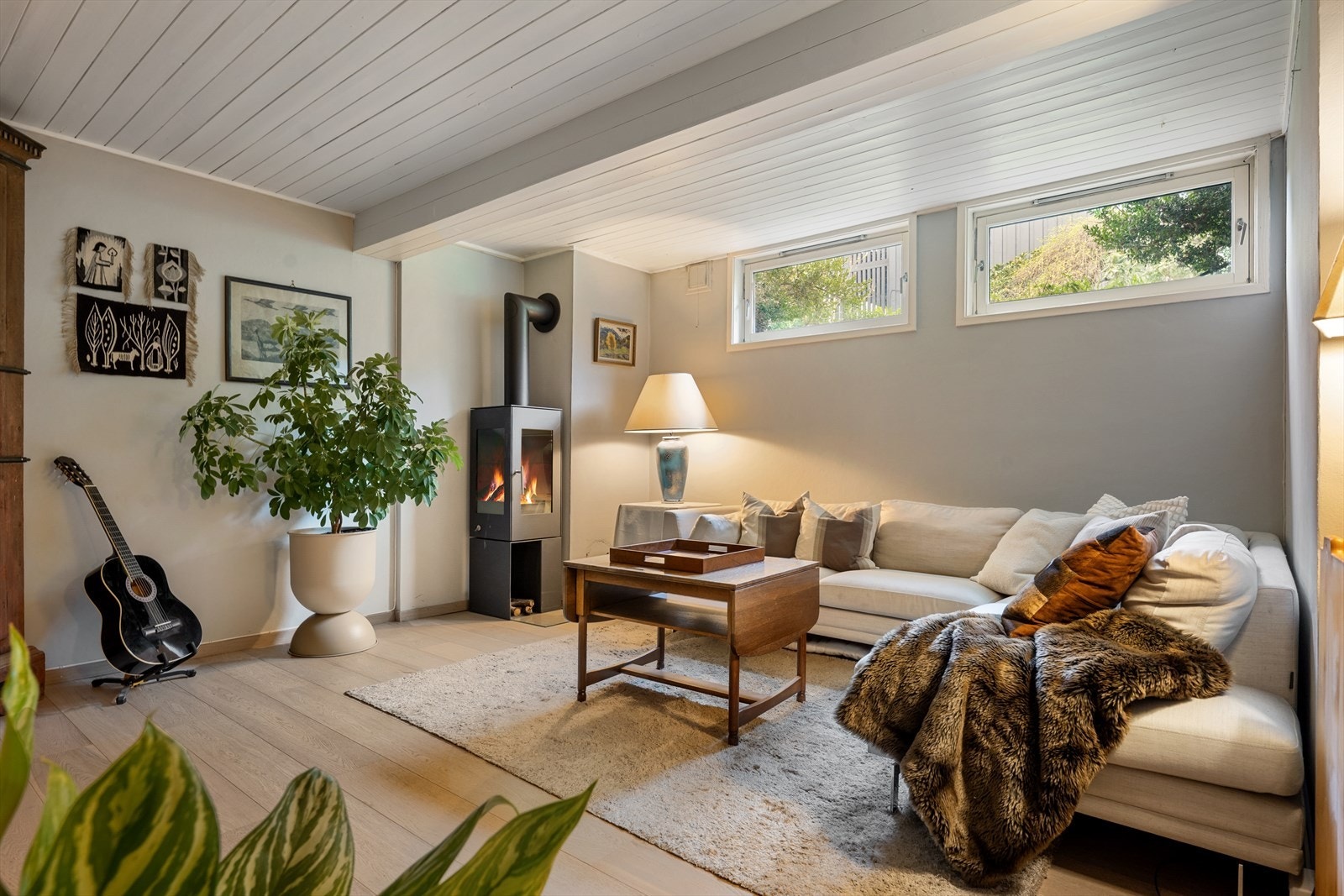 Kjellerstue/ Tv-stue med parkett på gulv og ovn. Her er det godt med plass til sofagruppe, TV- benk samt diverse hylleløsninger til oppbevaring. Varmekabler i gulv. Galleribilde