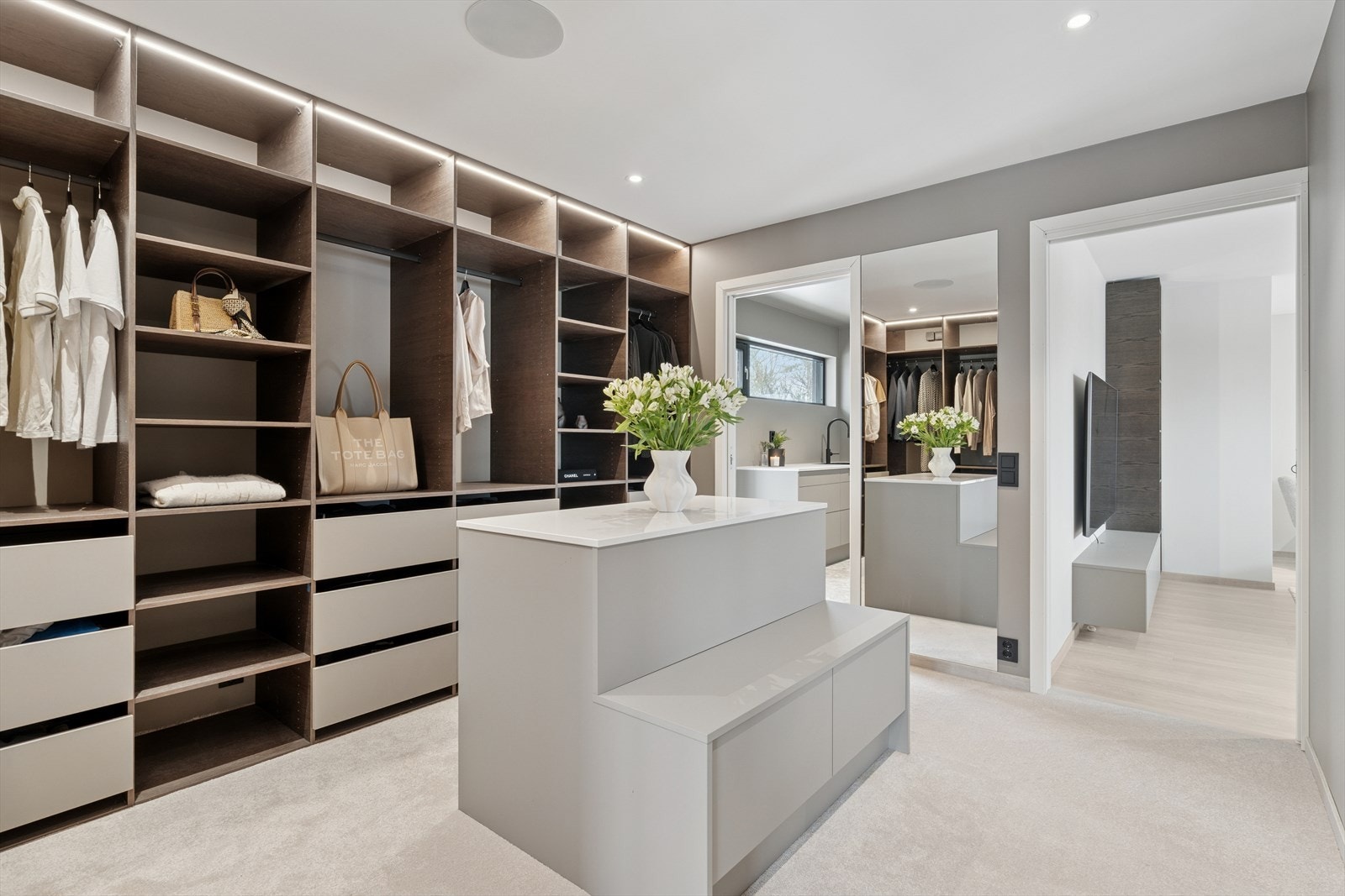 Garderoberommet har innredning fra Designa med hyller, skuffer, hengeplass og integrert belysning Galleribilde