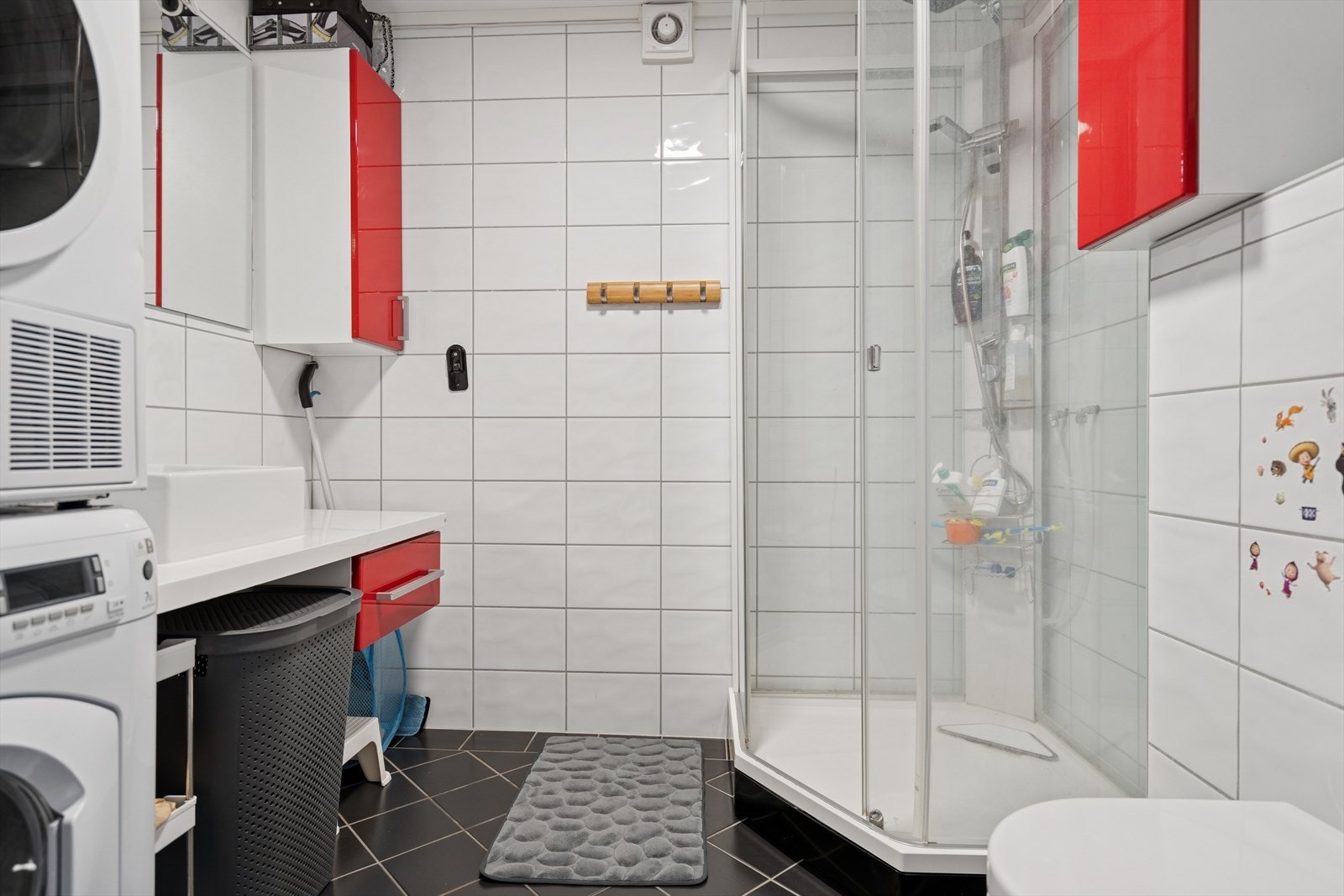 HYBEL: Badet ble modernisert av tidligere eier og har flislagte overflater - Rommet er utstyrt med dusjkabinett, vegghengt toalett, opplegg for vaskemaskin og baderomsinnredning Galleribilde