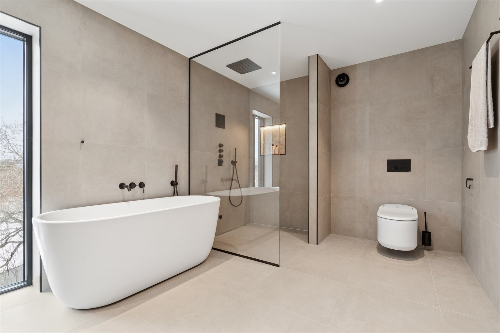 Her finner du badekar, vegghengt toalett (elektrisk), dusjnisje og baderomsinnredning Galleribilde