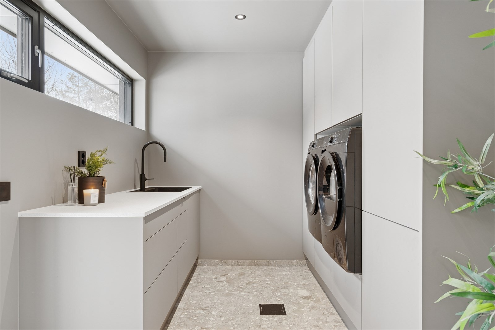 Rommet har praktisk innredning med plass til vaskemaskin/tørketrommel og utslagsvask Galleribilde