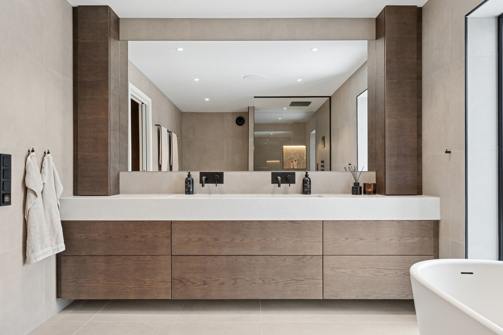 Innredningen består av dobbel servant med integrerte servantarmaturer, skuffer, hyller og stort speil Galleribilde