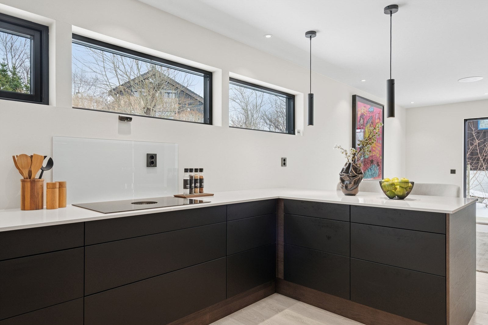 Kjøkkeninnredningen er levert av Designa og består av sorte slette fronter og hvit benkeplate med nedfelt komposittvask m/Quooker servant Galleribilde