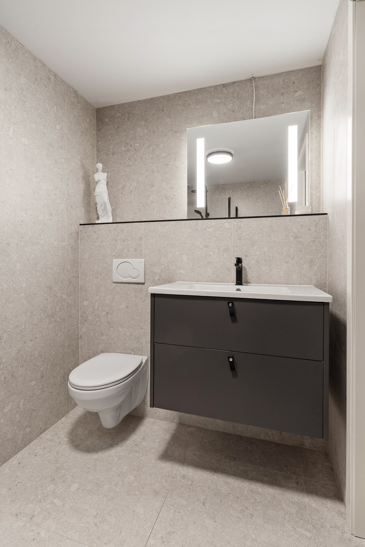 Rommet har innredning med nedfelt servant, veggfestet toalett, dusjhjørne og opplegg for vaskemaskin. Galleribilde