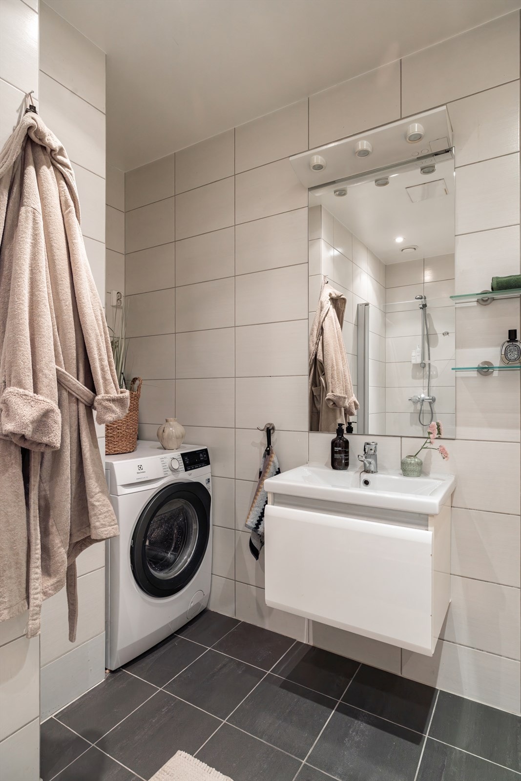 Innredningen består av heldekkende servant med servantskap, speil, vegghengt toalett og dusjhjørne med svingbare glassdører. Galleribilde