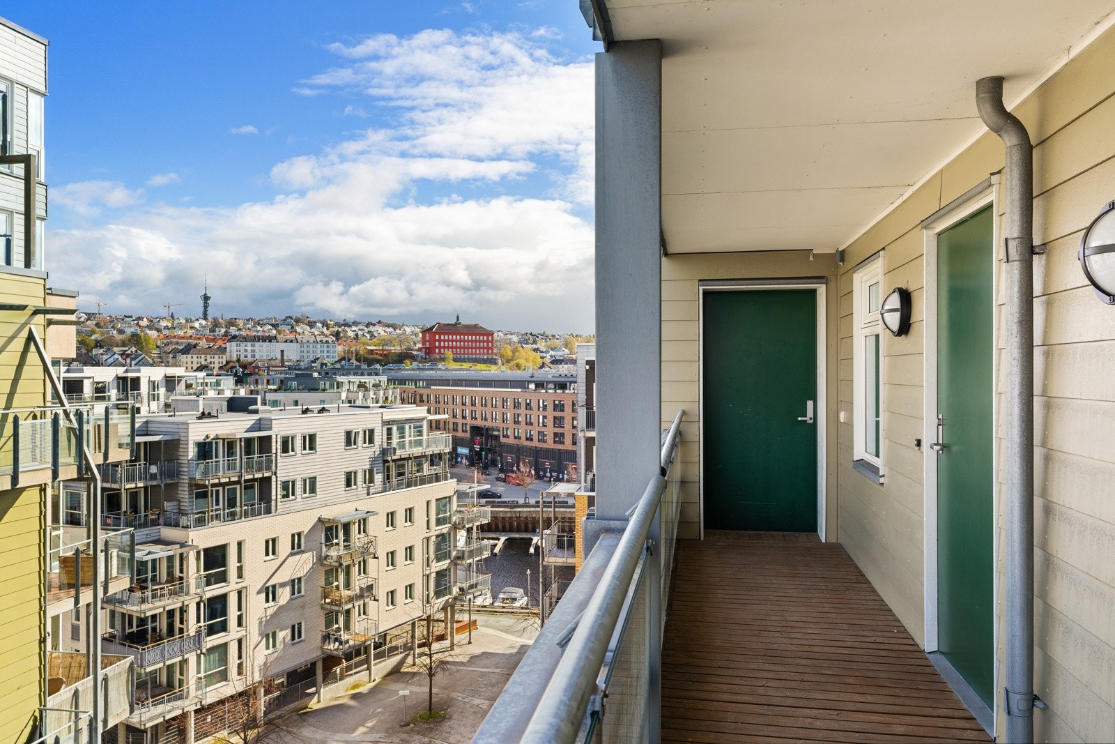 Fra byggets første plan tar man heisen opp til sjuende etasje. Leiligheten ligger da med inngang fra en oversiktlig og delvis overbygd svalgang. Galleribilde