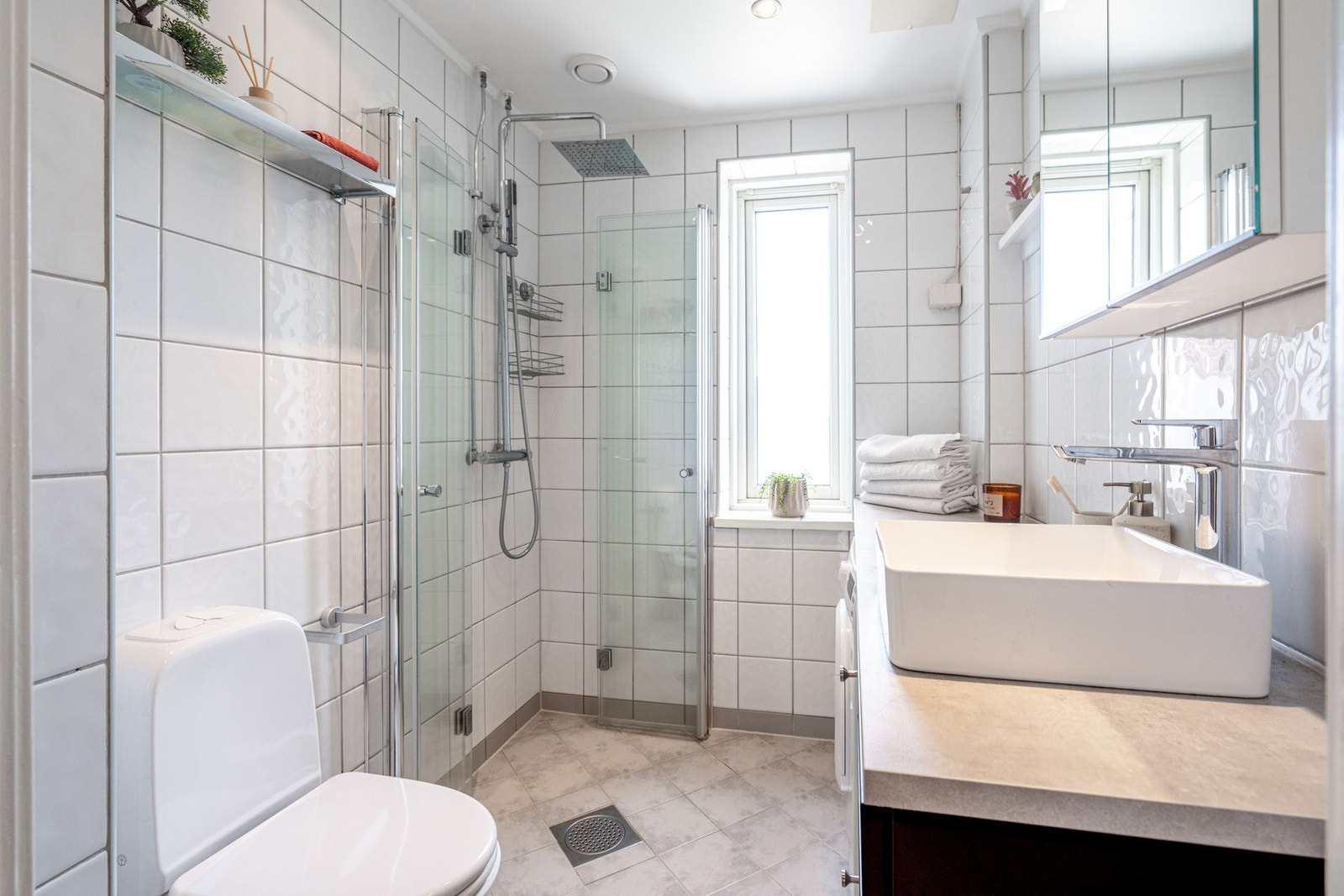 Lyst, flislagt baderom med downlights i himling og varme i gulv. Galleribilde