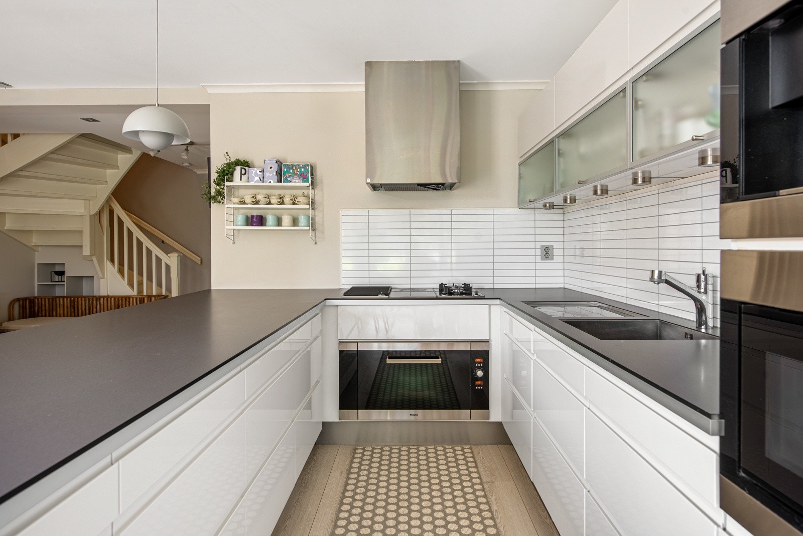 På langveggen er det høyskap og overskap, flere med frostede glass. Øvrige fronter er hvite, i høyglans utførelse. Galleribilde