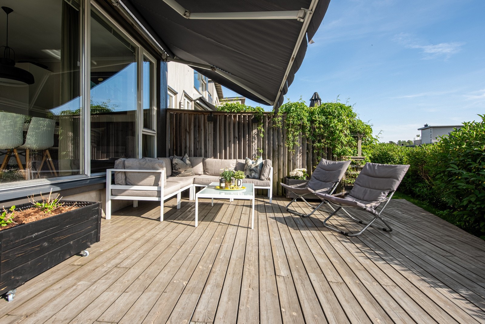 På terrassen er det spaltegulv av tre, levegger mot naboene og en frodig hekk i front. Galleribilde