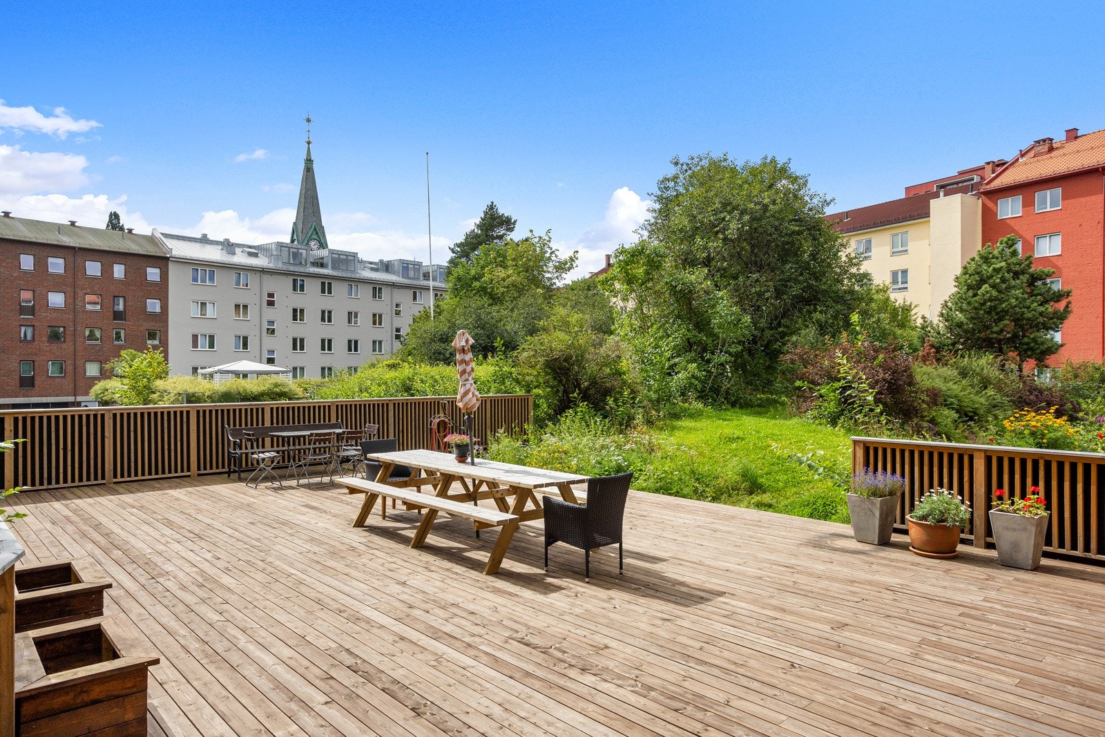 Bakgård opparbeidet med blandt annet asfaltert internvei, gressplen, sittegrupper trær, prydbusker, og diverse beplantning. Galleribilde