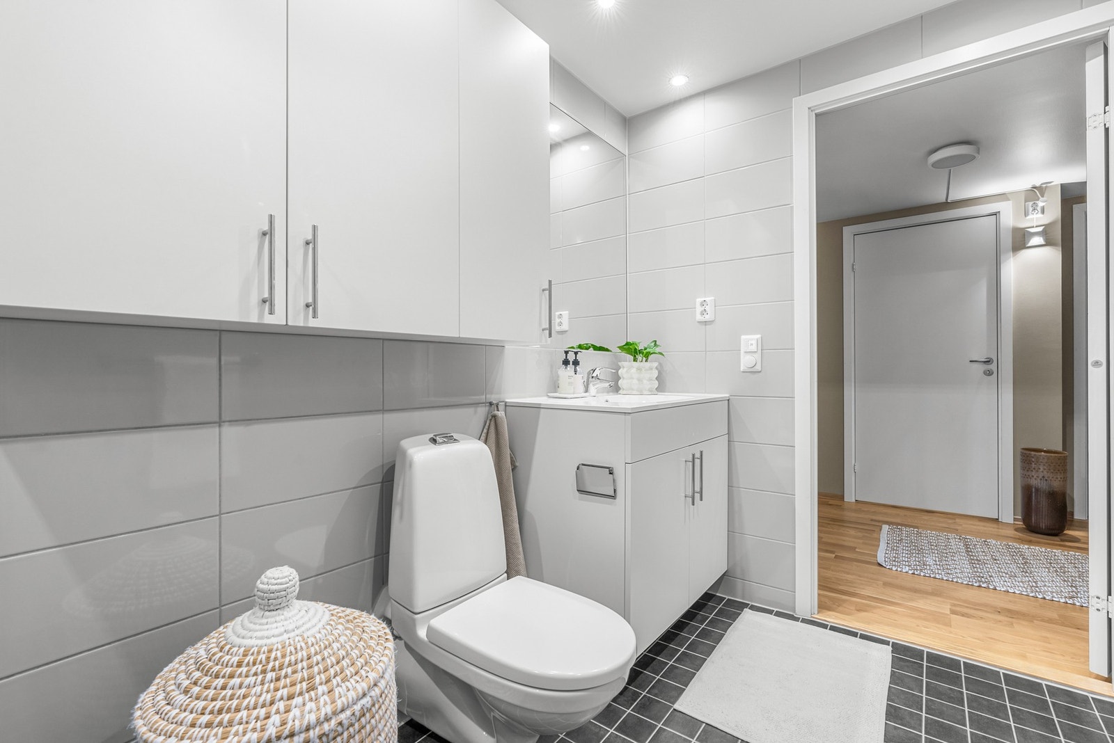 Innredning og toalett er veggehengt. Vaskemaskinen, som medfølger, er plassert innerst i en nisje. Dusjdørene kan felles inn. Galleribilde