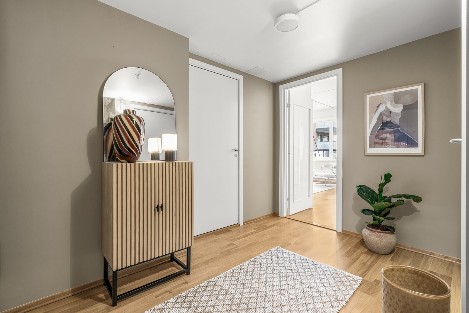 Leiligheten tar deg imot en en romslig og innbydende entré. Legg merke til at døren inn til oppholdsrommet har glassfelt. Galleribilde