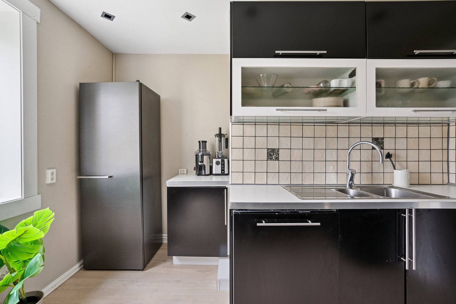 Benkeplaten i laminat er utstyrt med en nedfelt stålkum, og det er fliser mellom benken og overskapene. Galleribilde